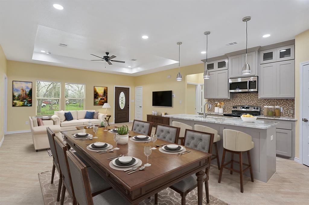 a large dining room with stainless steel appliances granite countertop a table chairs and a kitchen view