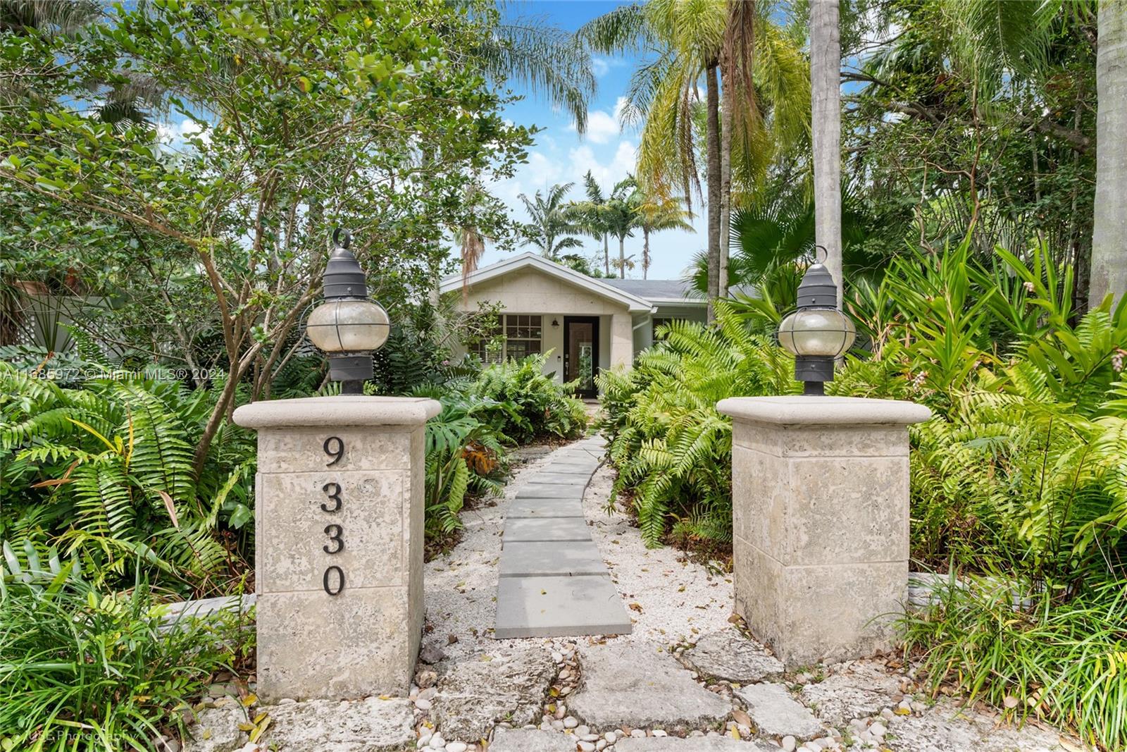 a view of a house with a fountain and plants