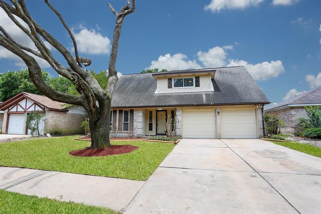 a front view of a house with a yard and a garage