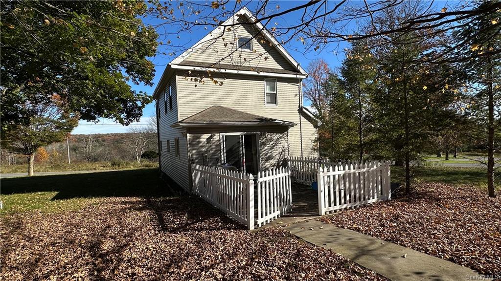 a view of a small house with wooden fence