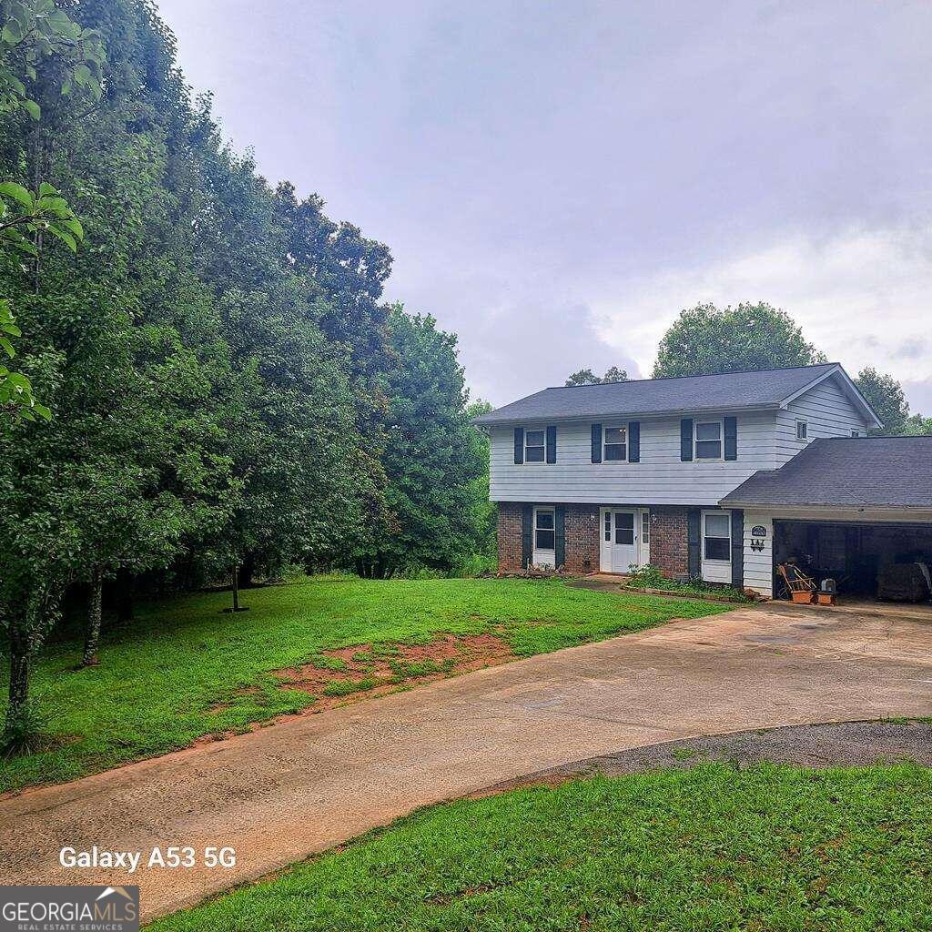 a front view of a house with a yard and trees