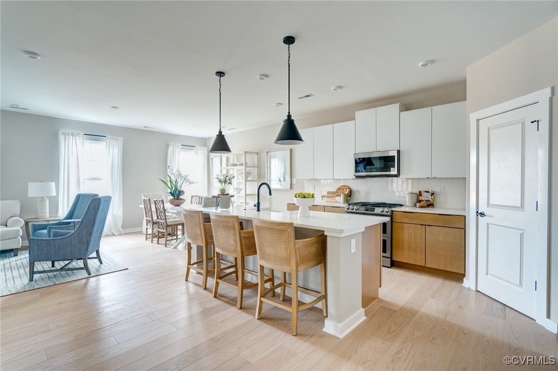 a open kitchen with white cabinets and white appliances