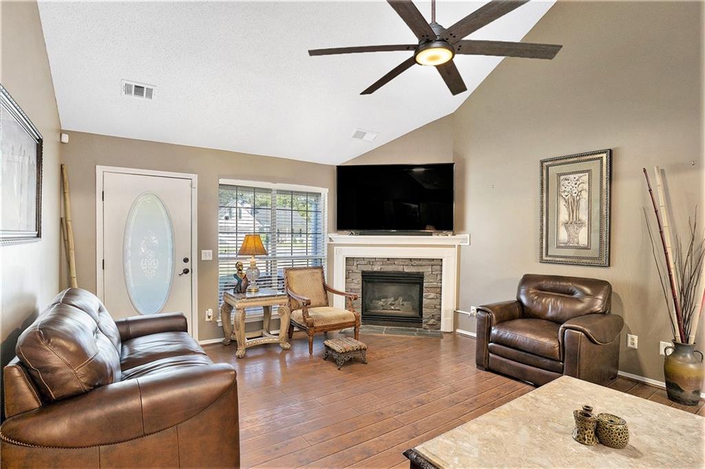 a living room with furniture a fireplace and a flat screen tv