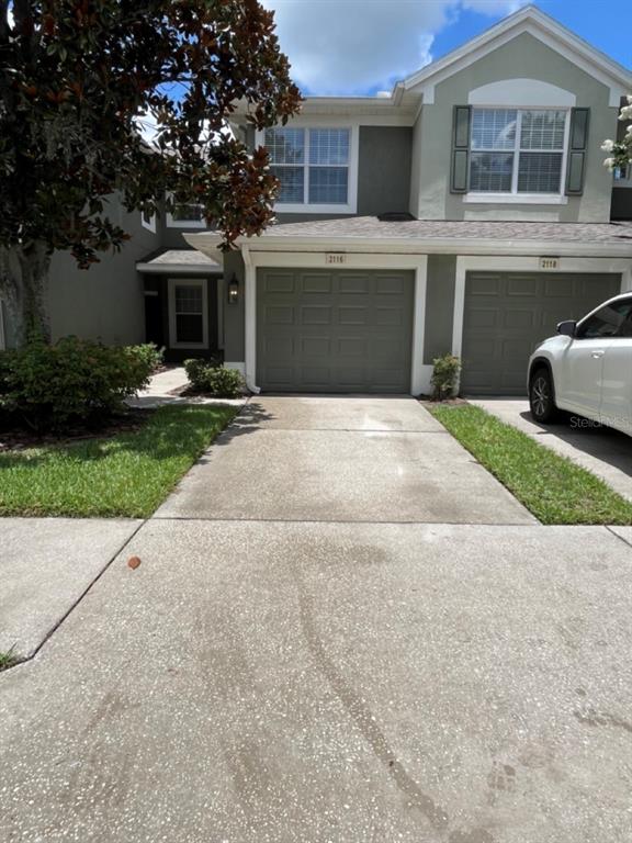 a front view of a house with a yard and a garage