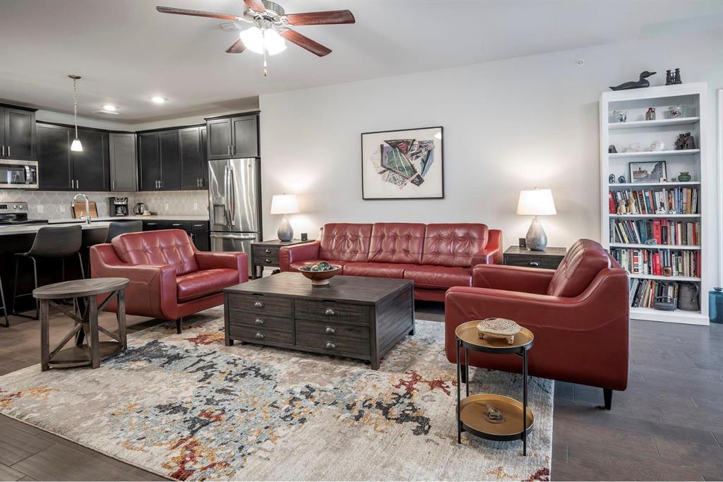 a living room with furniture a rug and kitchen view