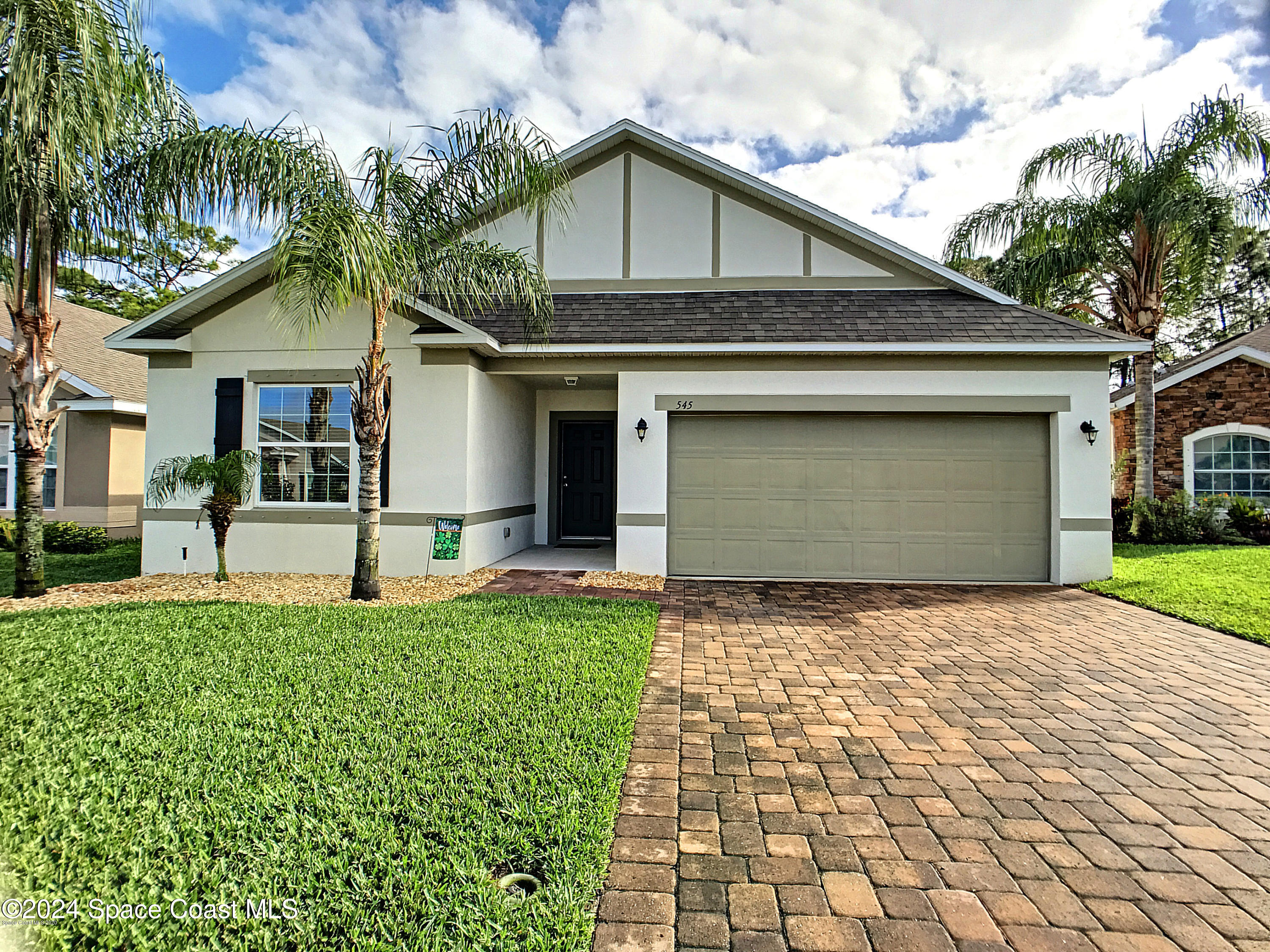 a front view of a house with a yard and garage