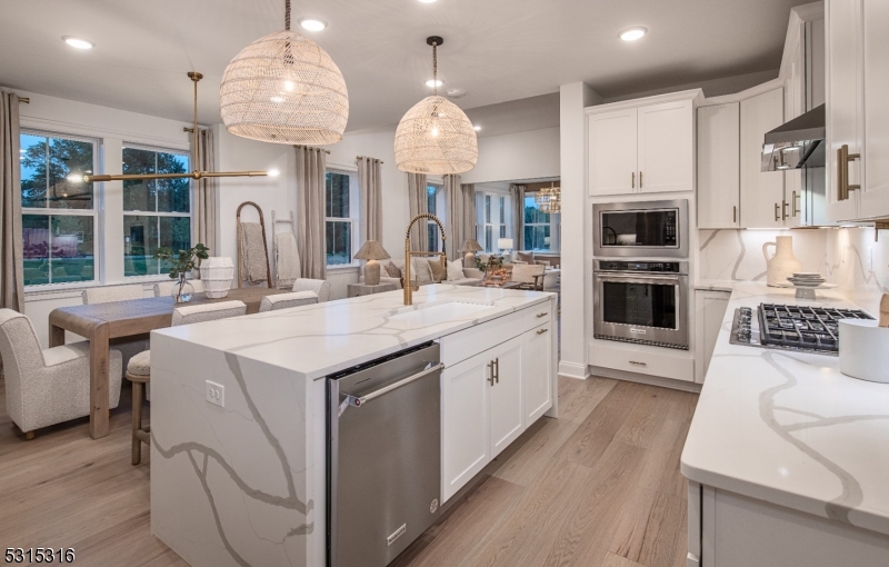 a kitchen with kitchen island granite countertop a sink a counter space appliances and cabinets