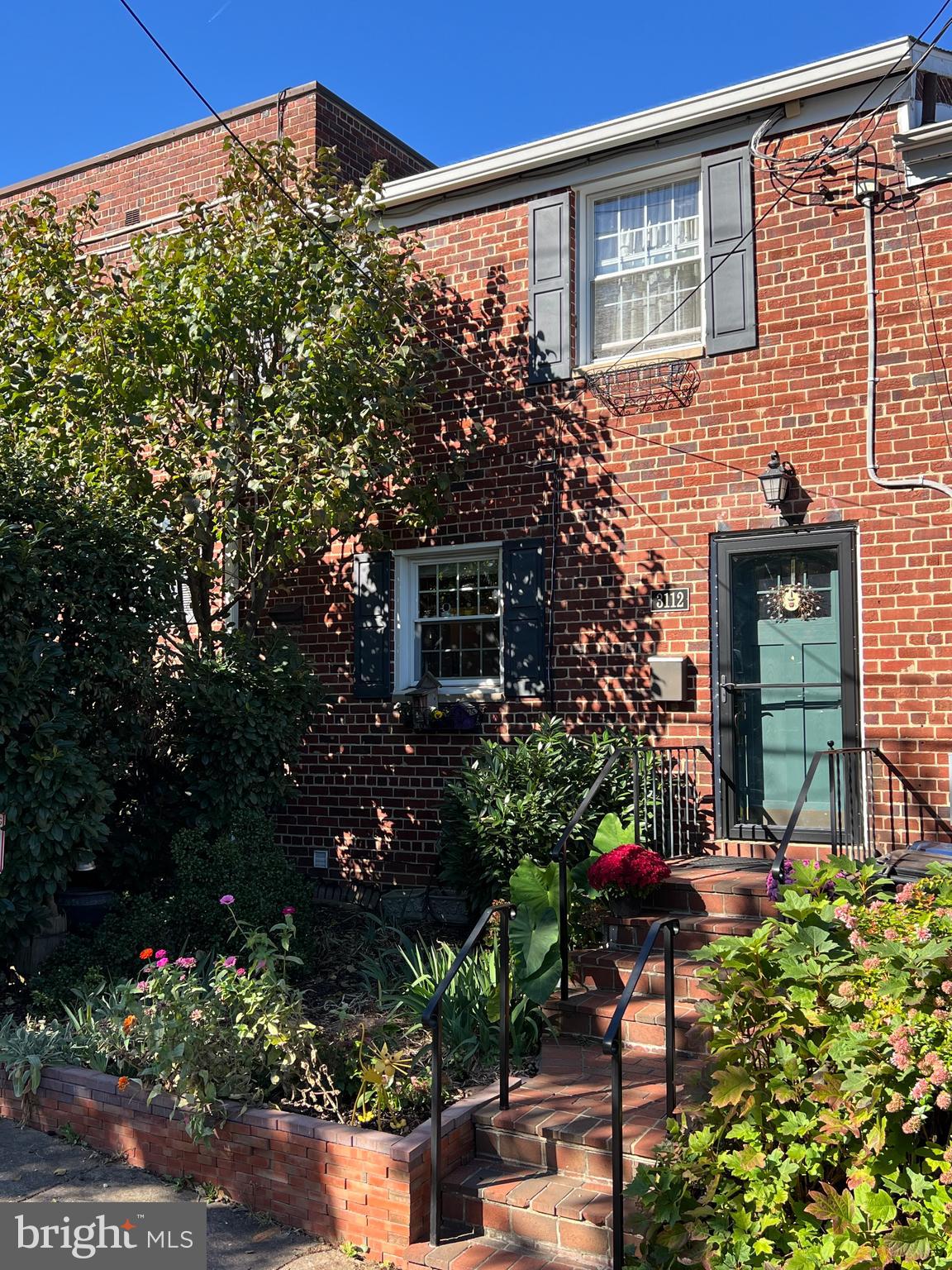 a flower garden is sitting in front of a house