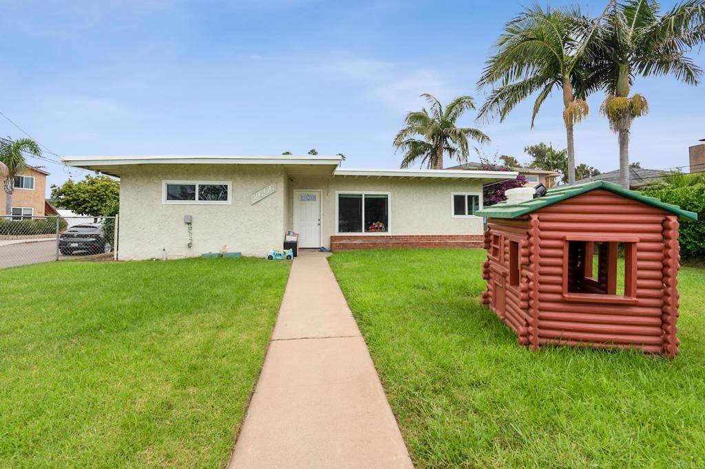 a front view of a house with a garden and yard