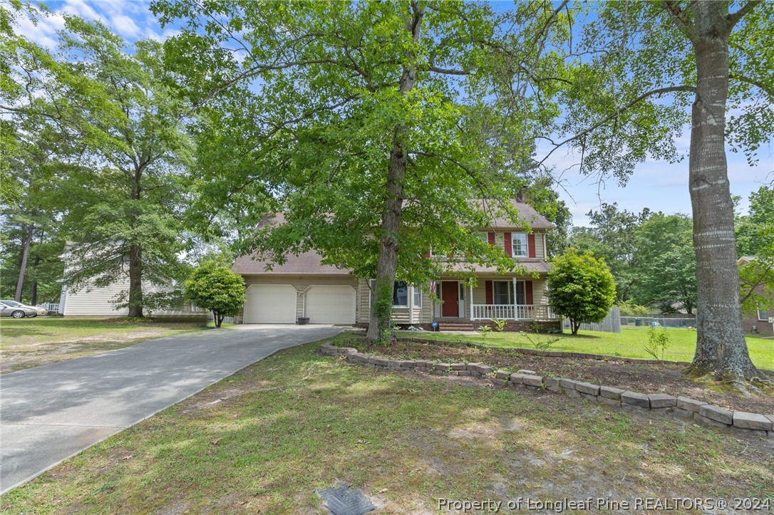 a front view of a house with a yard and trees