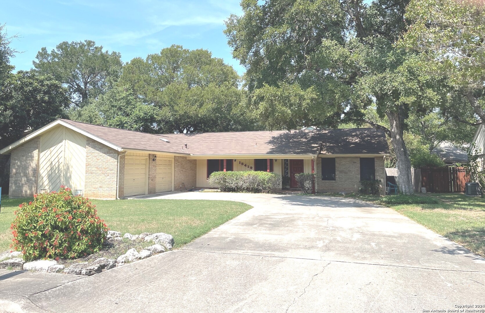 a front view of a house with a yard and potted plants