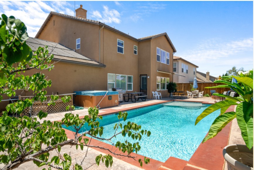 a front view of a house with swimming pool garden and patio