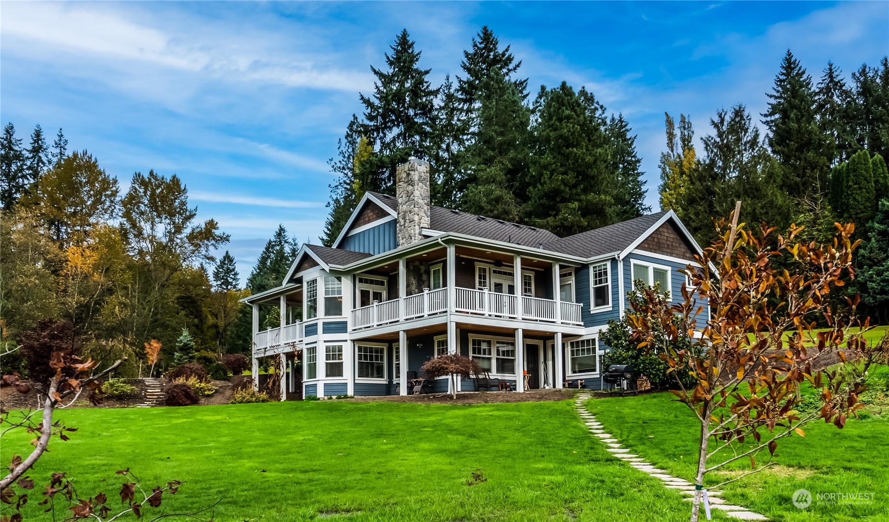 a view of a house with a big yard and large trees