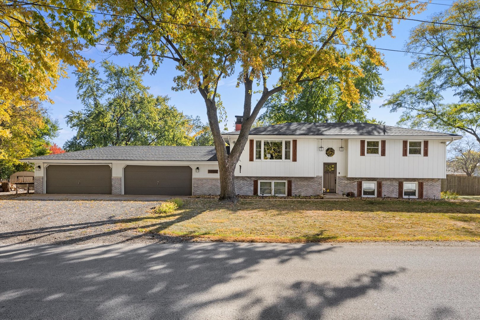 a view of a house with a large tree and a yard