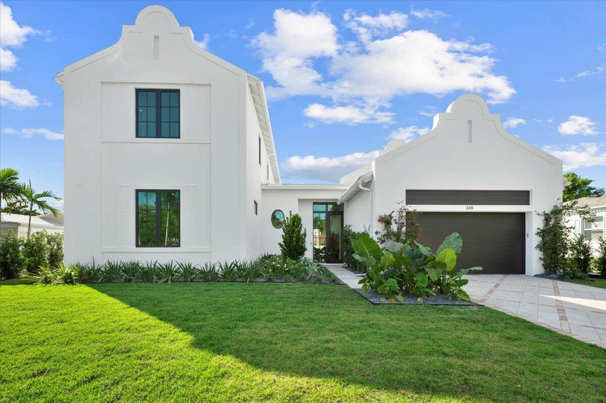 a front view of a house with a garden