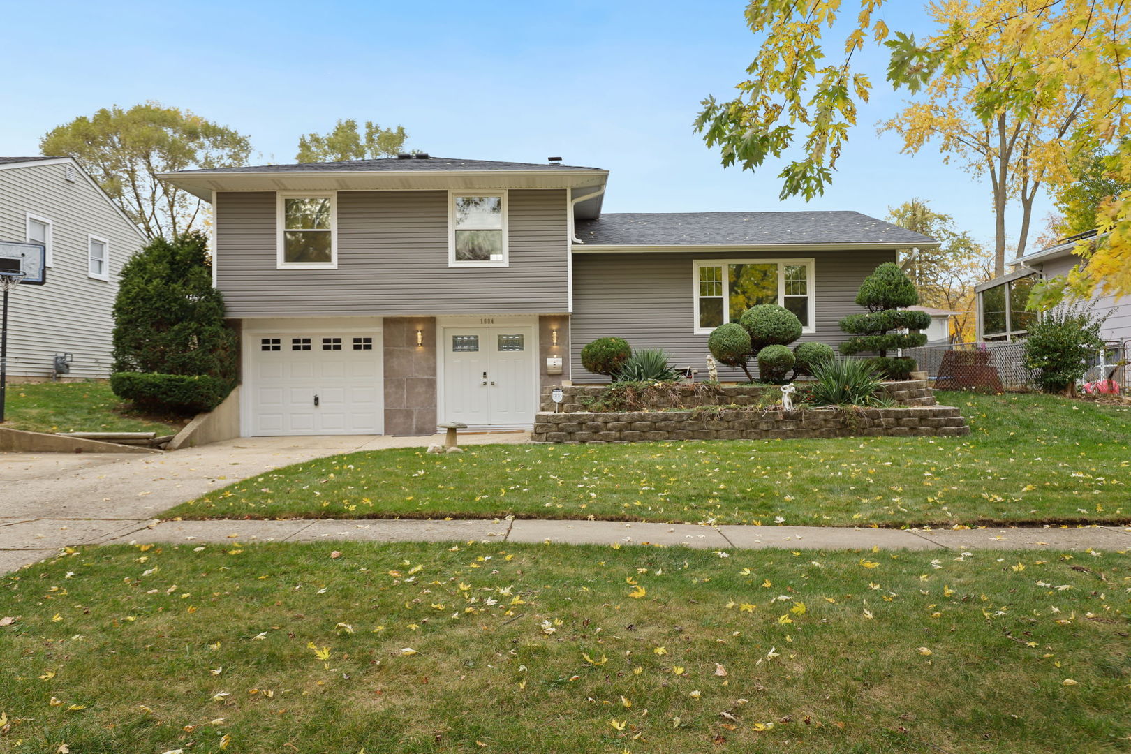 a front view of a house with a garden and yard