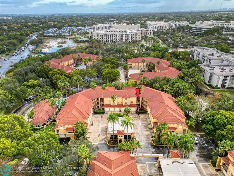 an aerial view of residential houses with outdoor space and parking