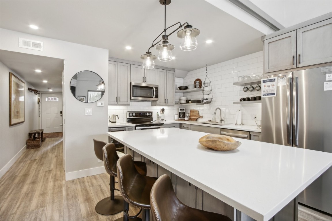 a kitchen with kitchen island a sink appliances and cabinets