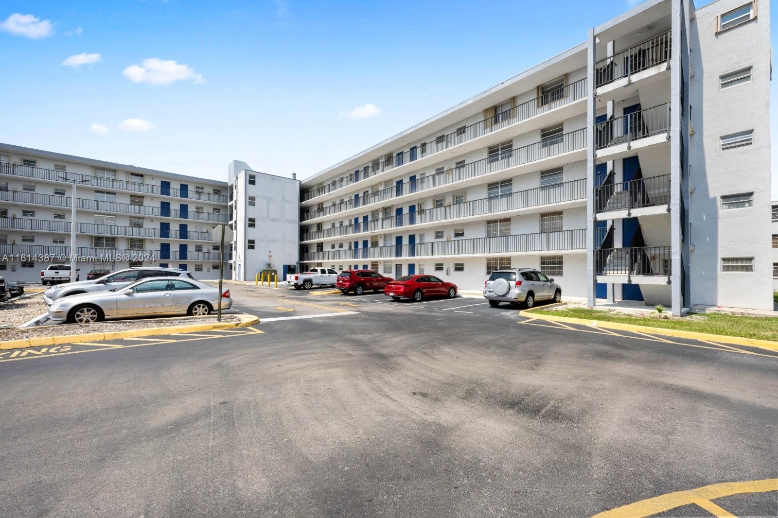 a view of building with cars parked in front of it