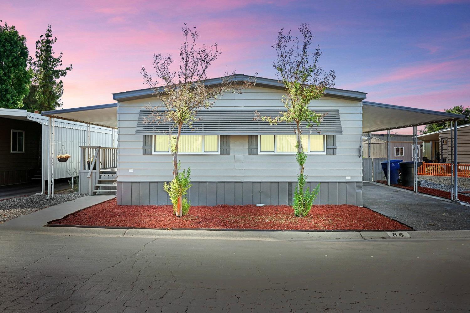 a view of a house with a patio and a yard