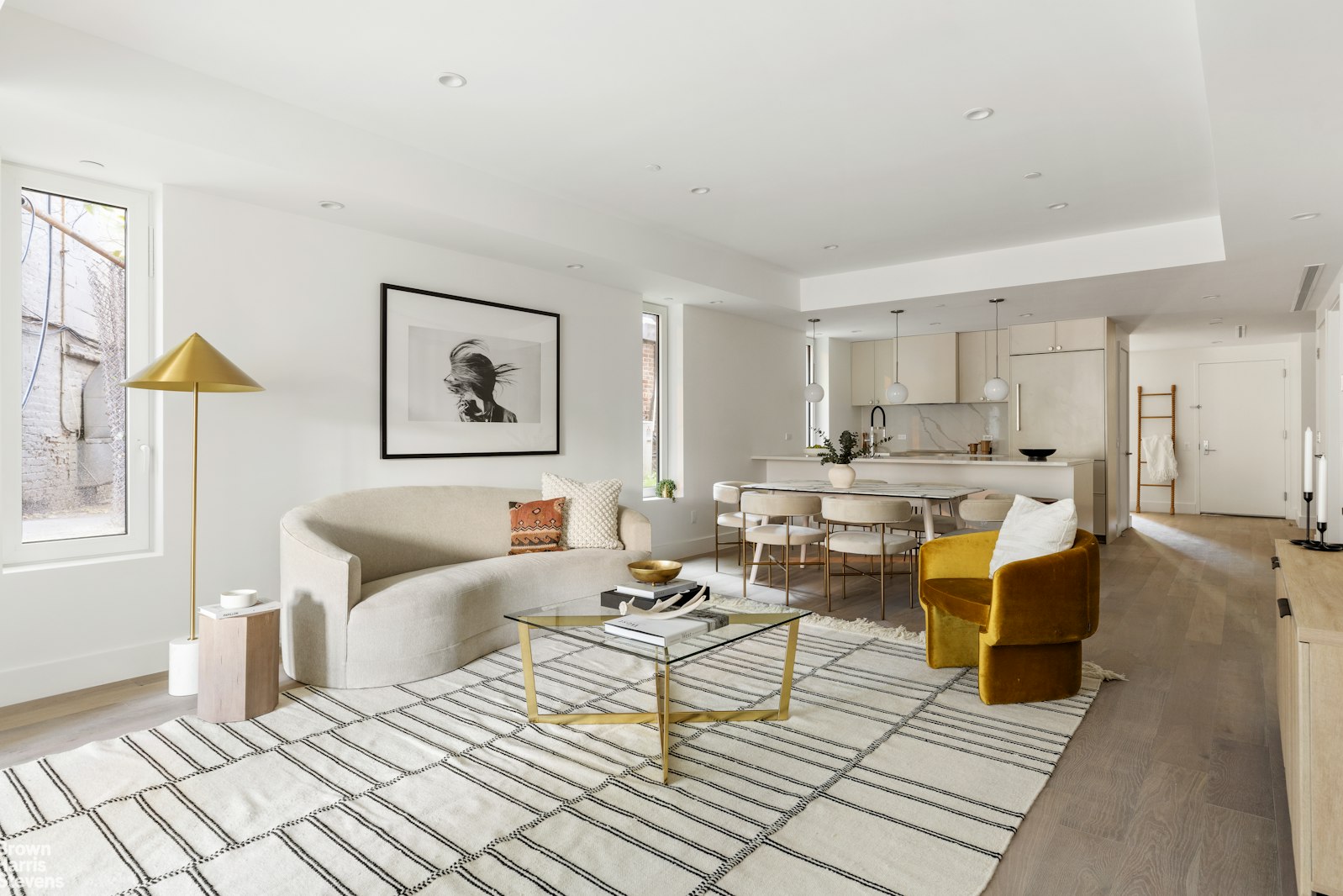 a living room with furniture and a dining table with kitchen view