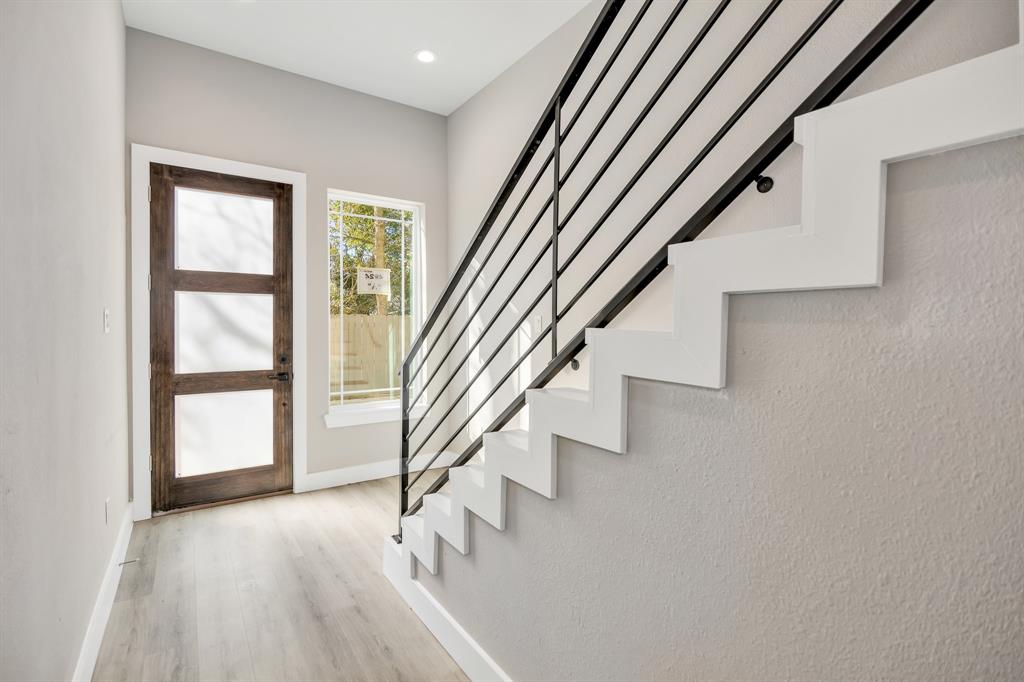 an entryway in a hall with a window and wooden floor