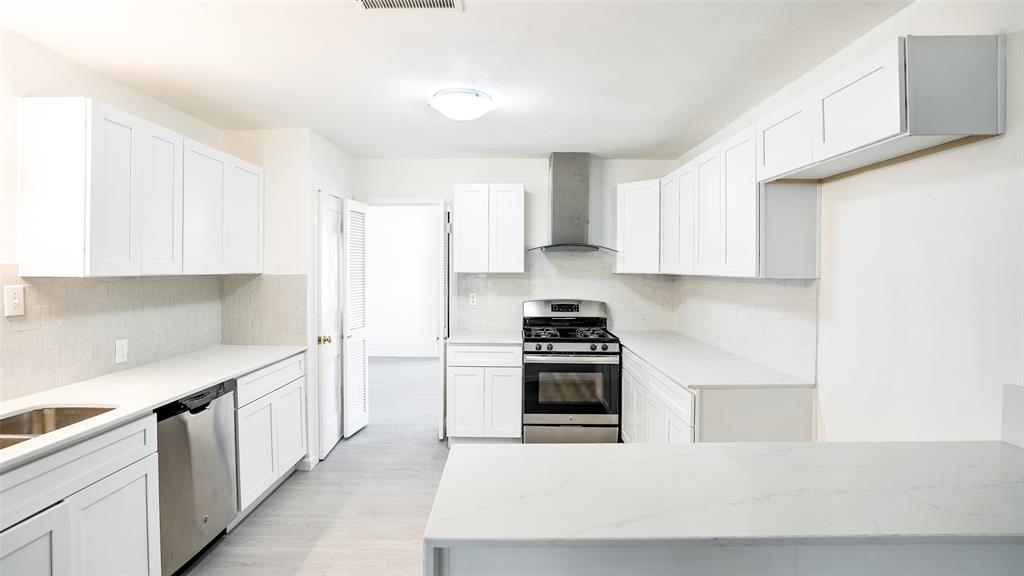 a kitchen with stainless steel appliances a stove a sink and a refrigerator