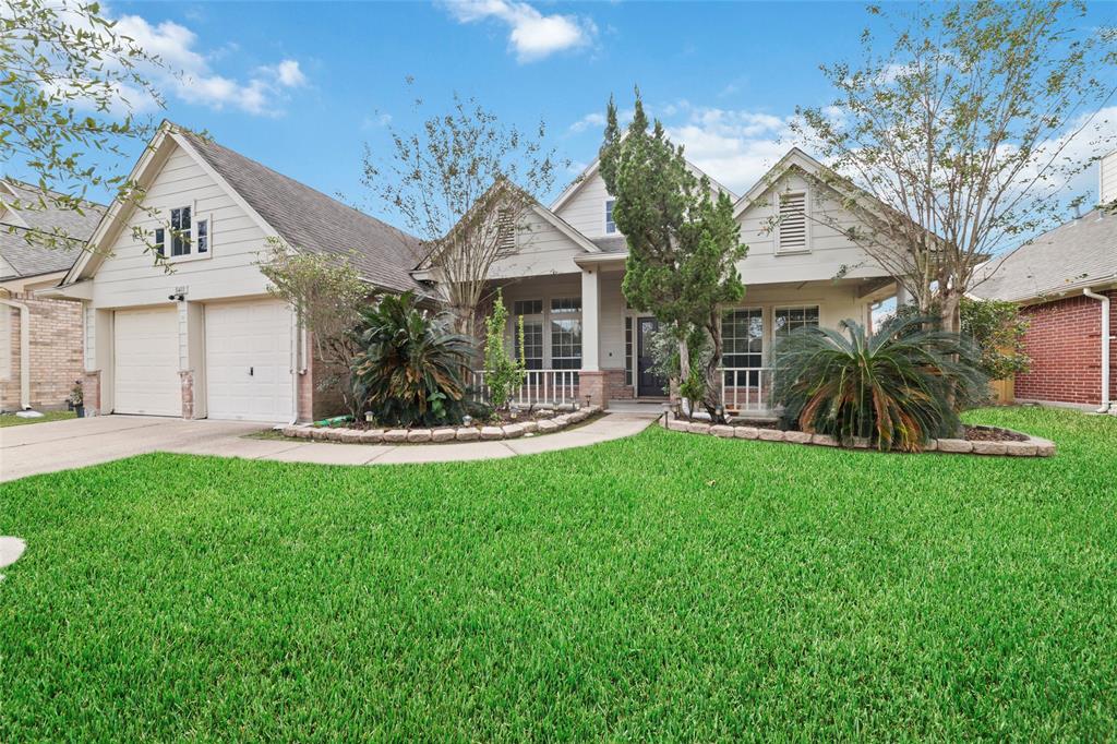 a view of a house with a big yard plants and large trees