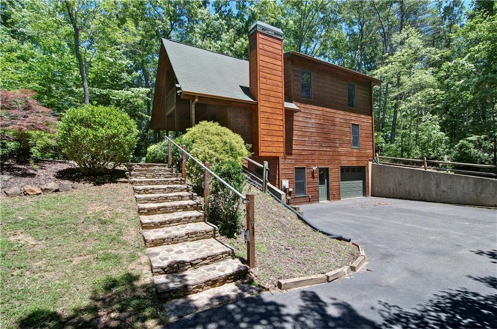 a view of a house with backyard and trees