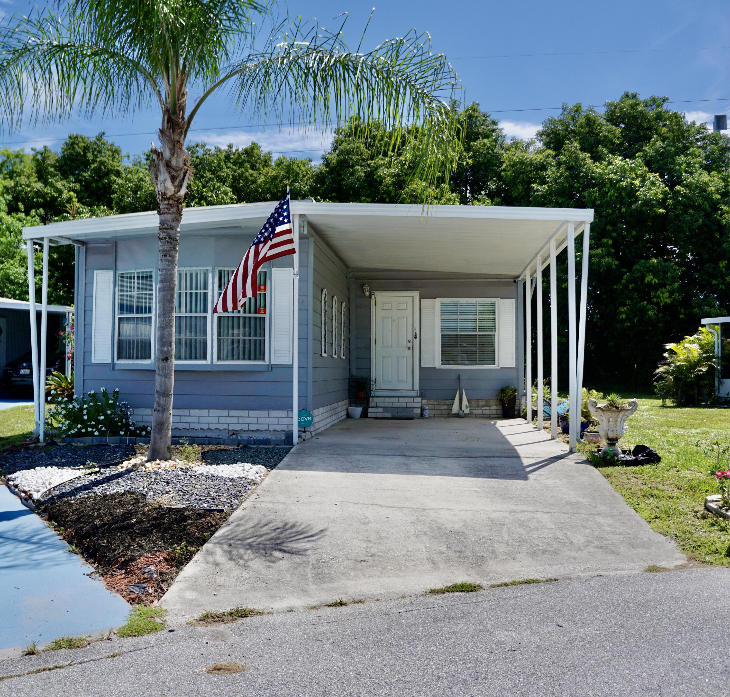 a view of a house with a yard and palm trees