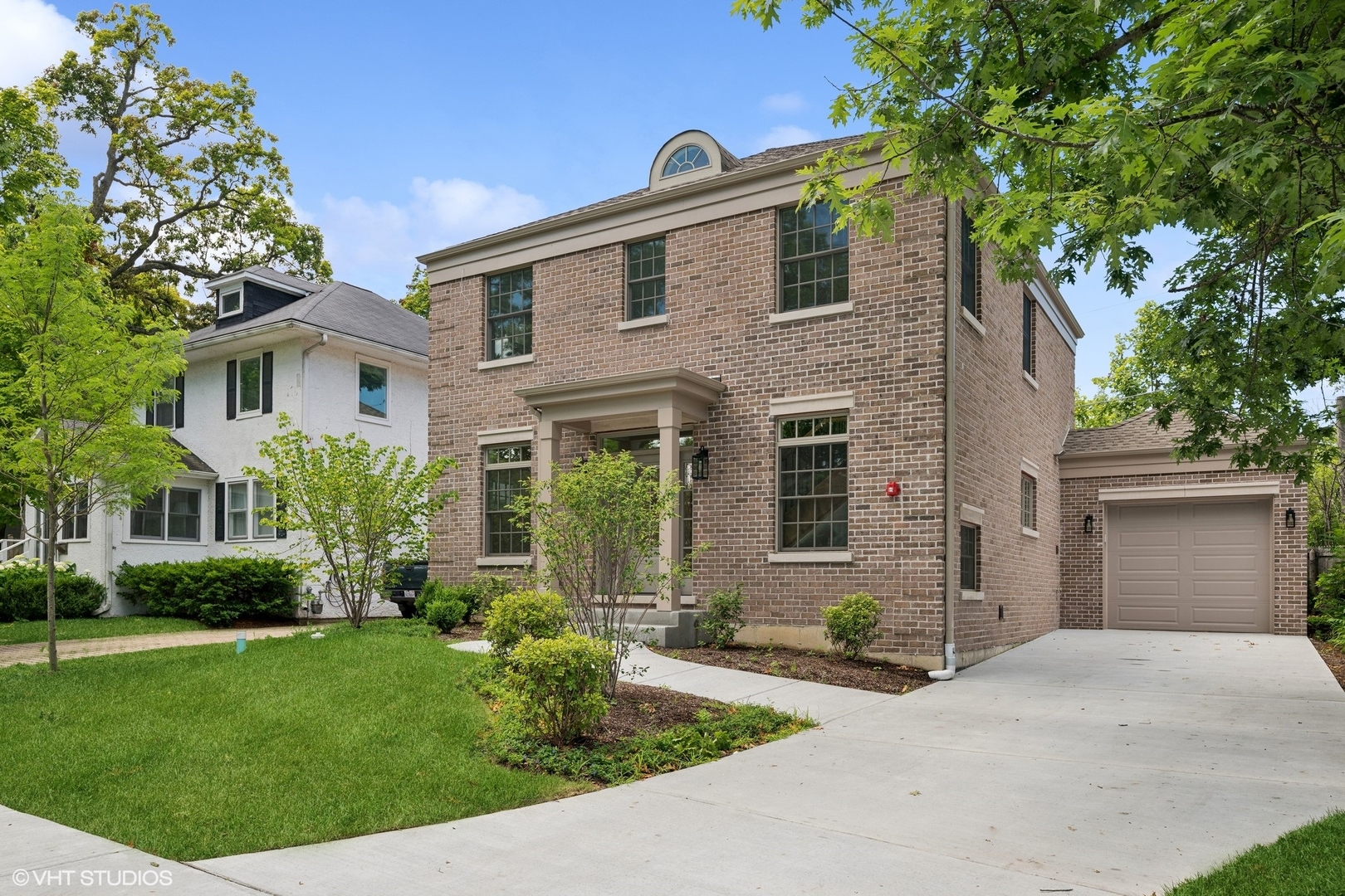 a front view of a house with a yard and potted plants