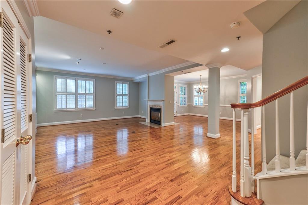 a view of empty room with wooden floor and fireplace