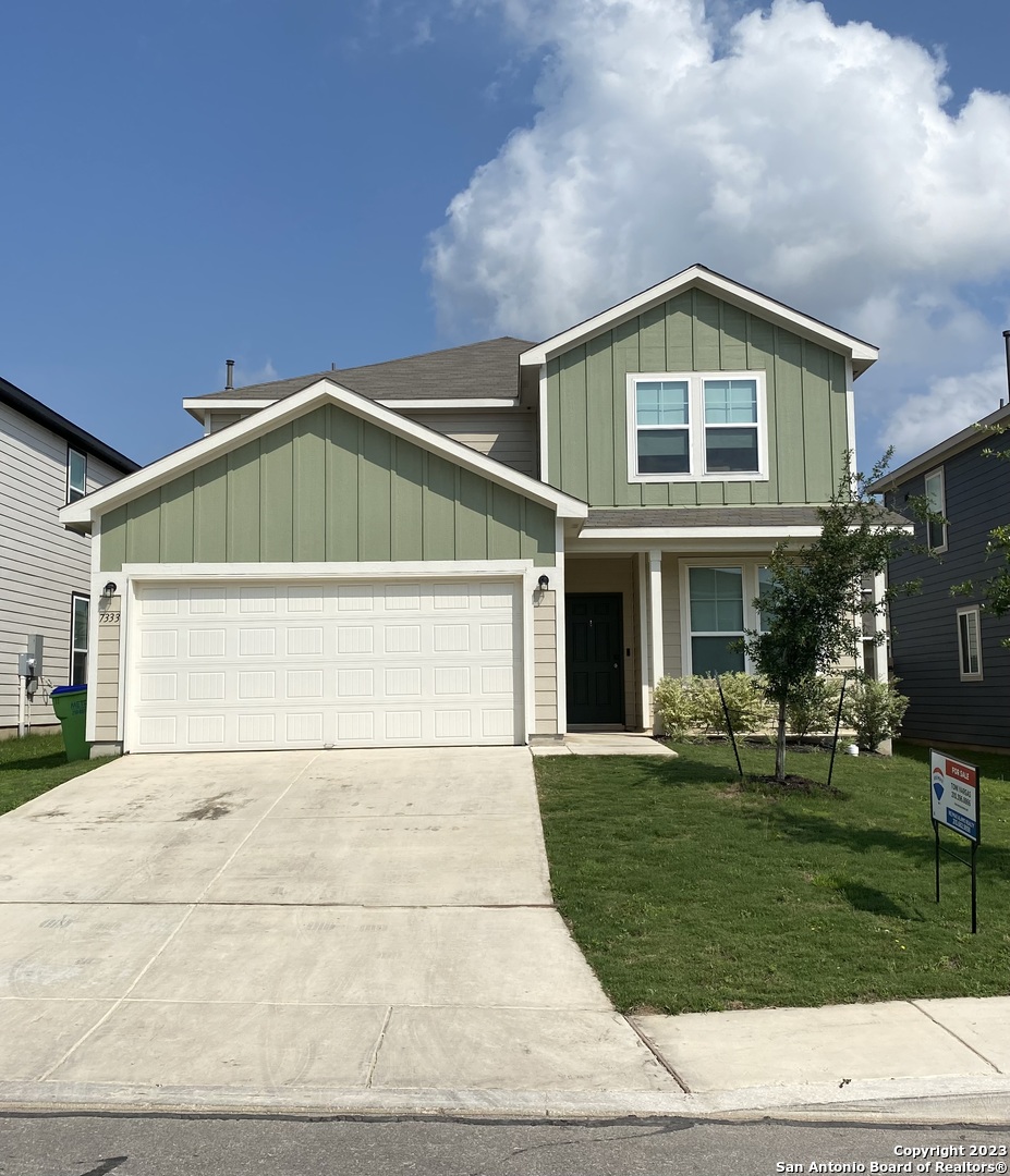 a front view of a house with a yard and garage