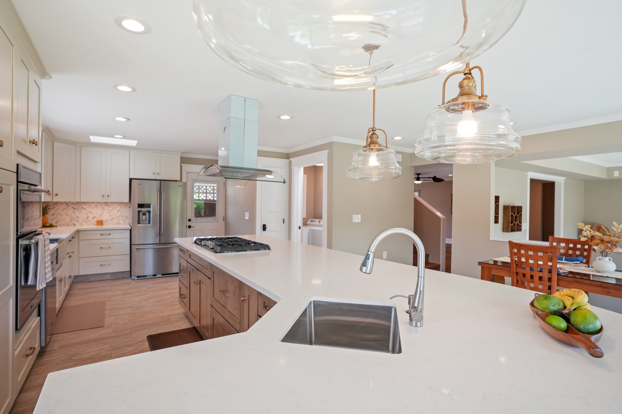 a kitchen with stainless steel appliances kitchen island granite countertop a sink and a refrigerator