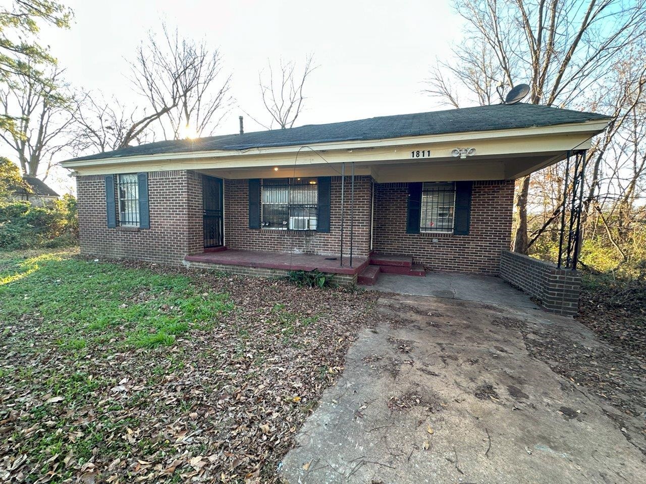 Ranch-style home featuring a porch and a carport