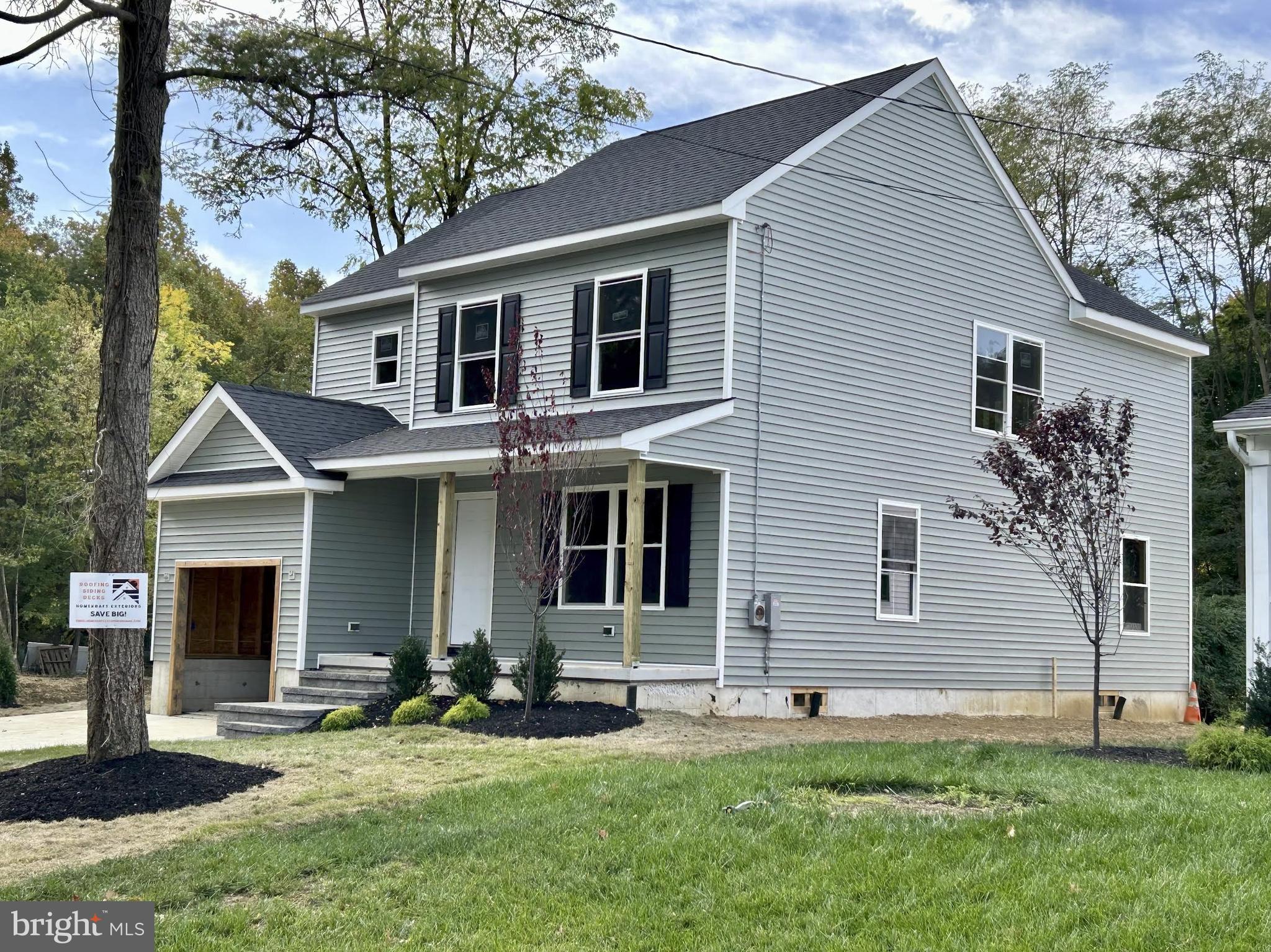 a front view of a house with a yard and trees