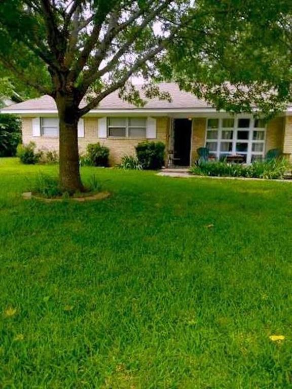 a front view of a house with a yard and green space