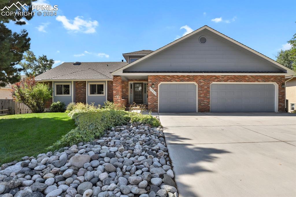 View of front of home with a garage and a front yard