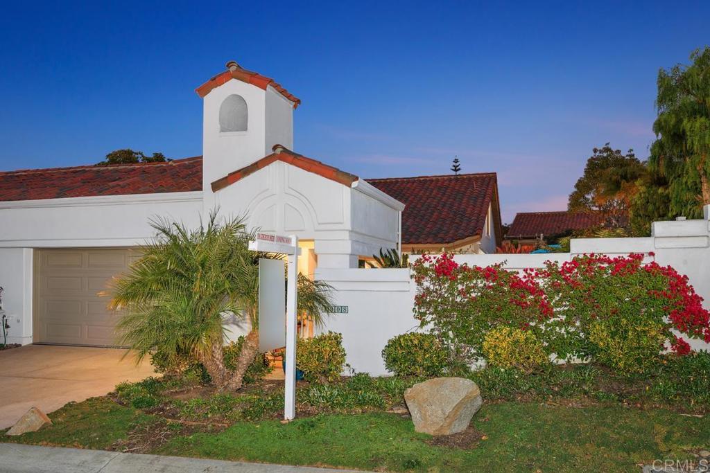 a front view of a house with a yard and fountain