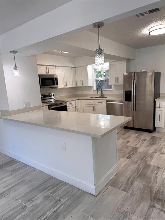 a kitchen with stainless steel appliances a refrigerator sink and microwave