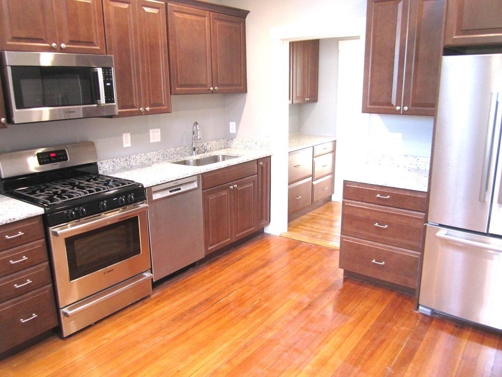 a kitchen with stainless steel appliances granite countertop a stove a microwave and a refrigerator