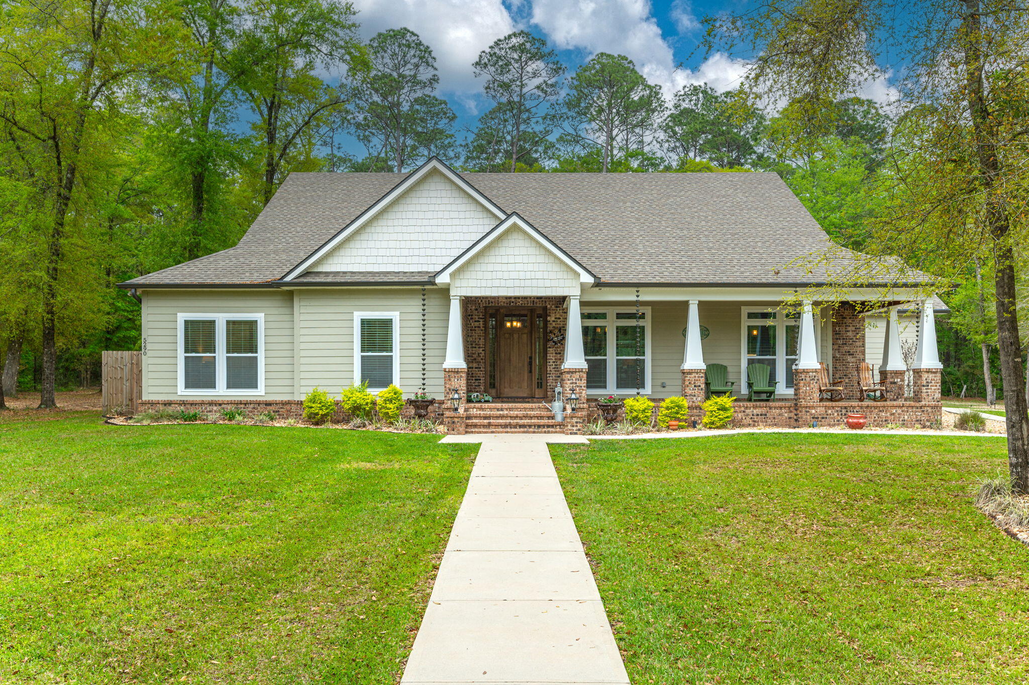 a front view of a house with swimming pool and porch with garden