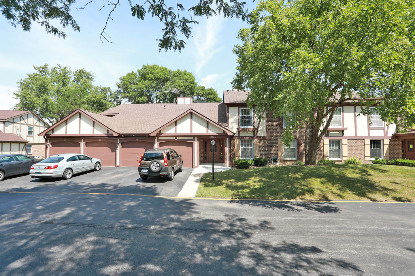 a front view of a house with a garden and parking space