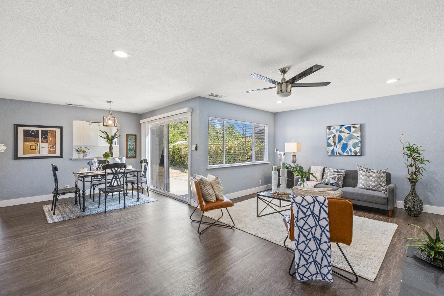 a living room with furniture dining table and a ceiling fan