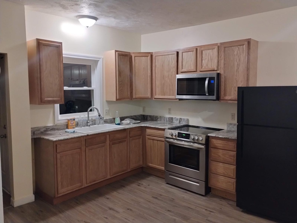 a kitchen with stainless steel appliances granite countertop a stove microwave and sink