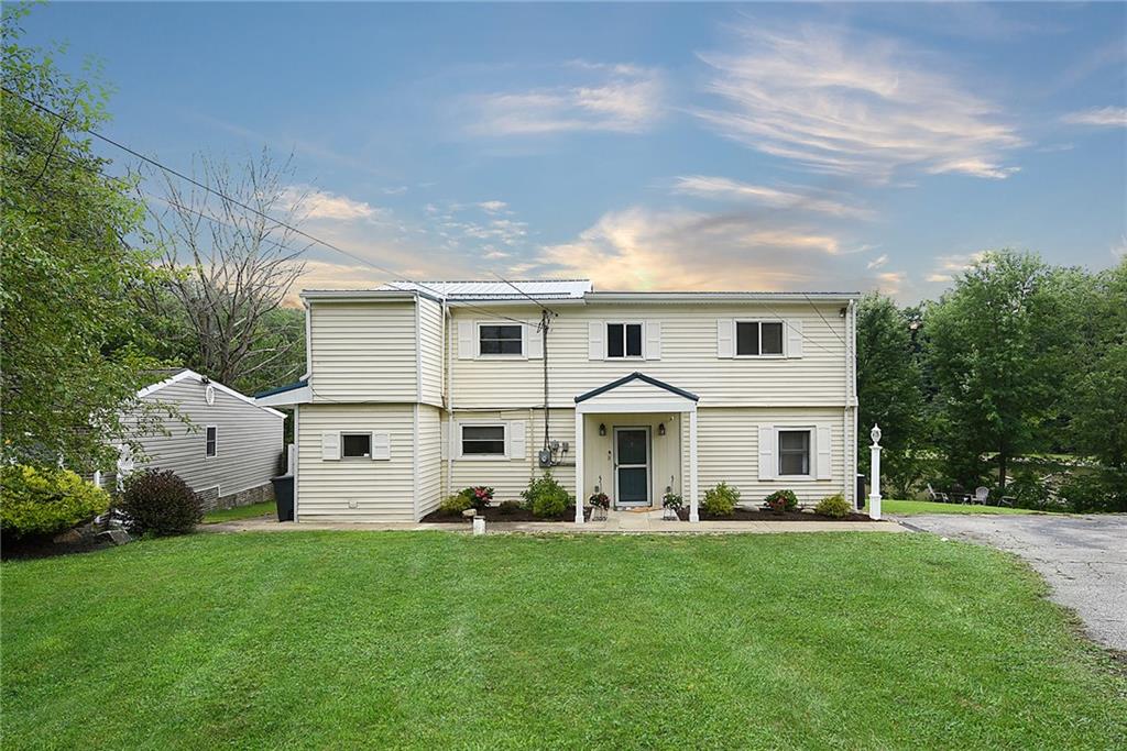 a front view of house with yard and green space