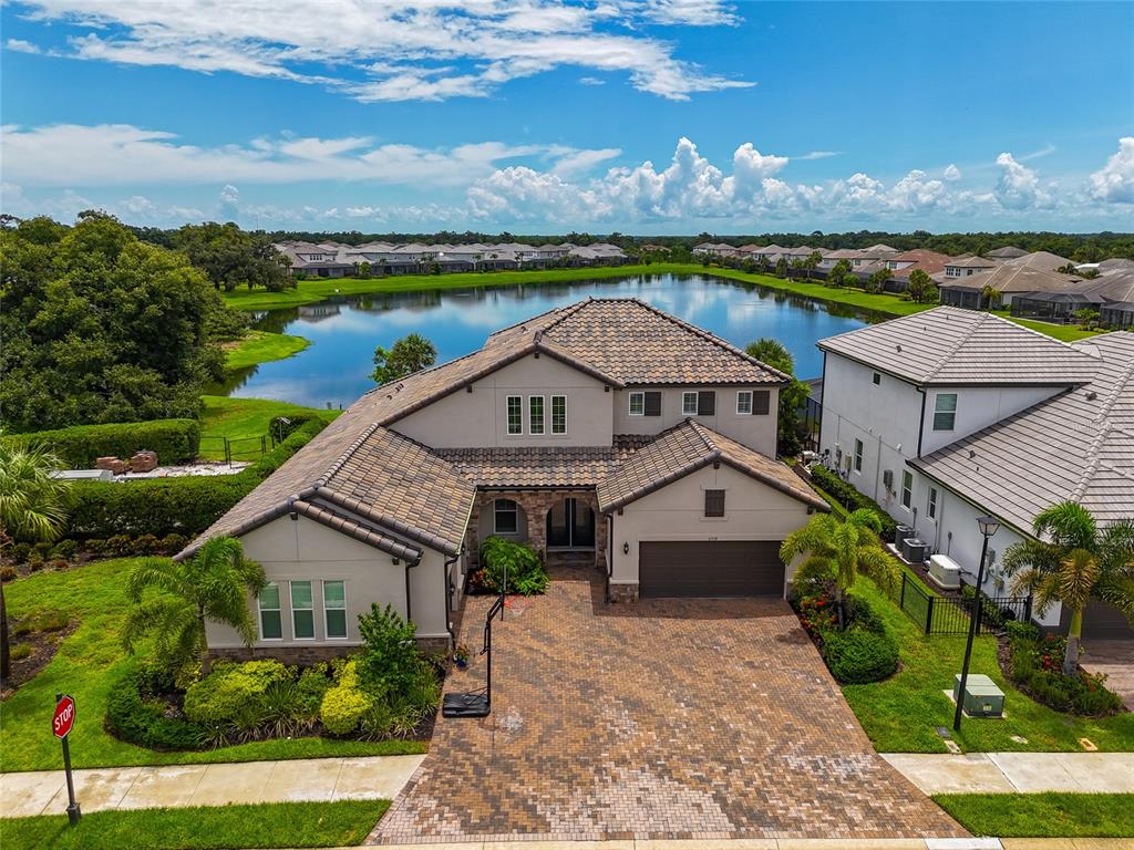 an aerial view of a house with a garden and lake view