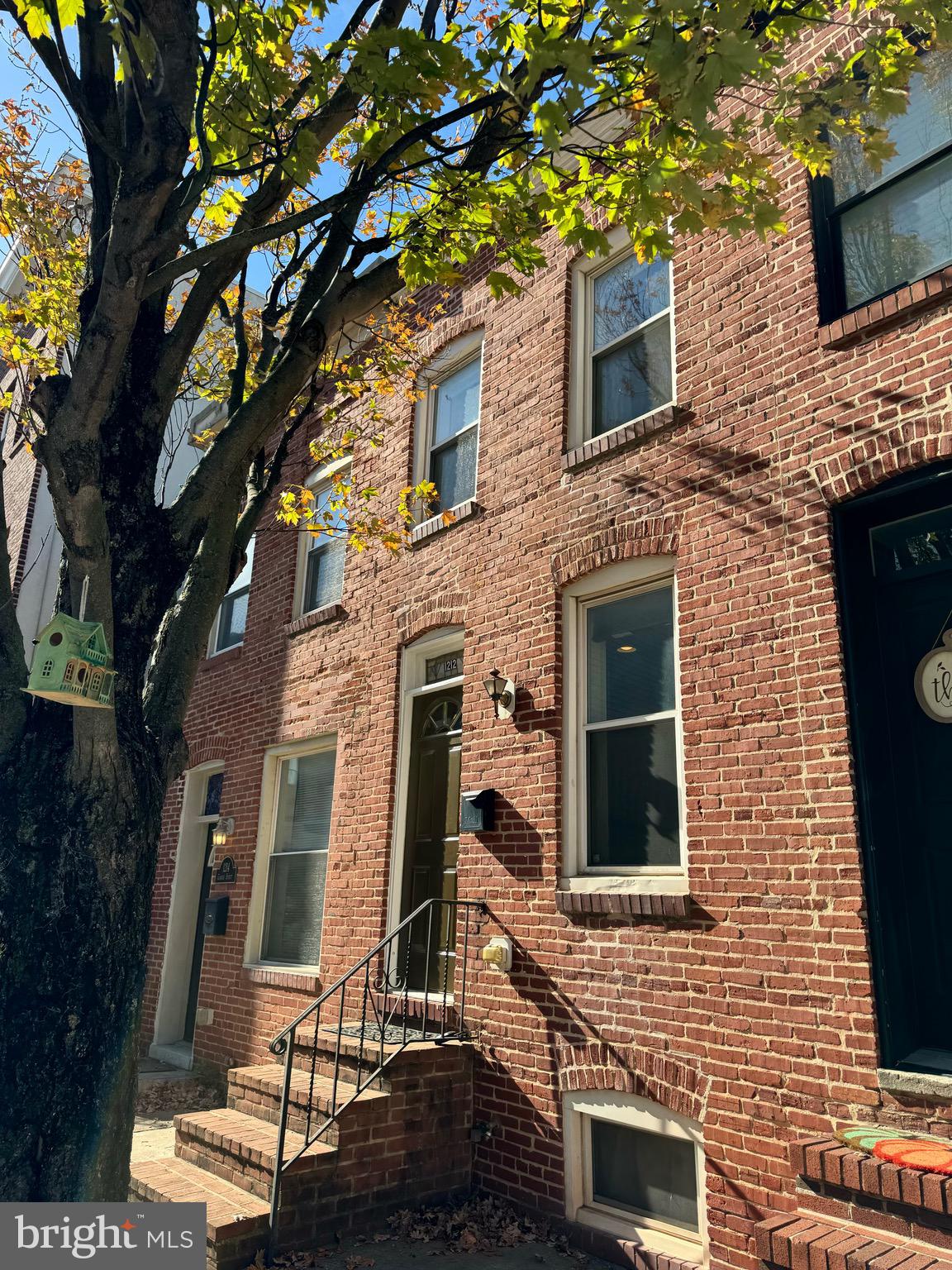 a front view of a building with a tree