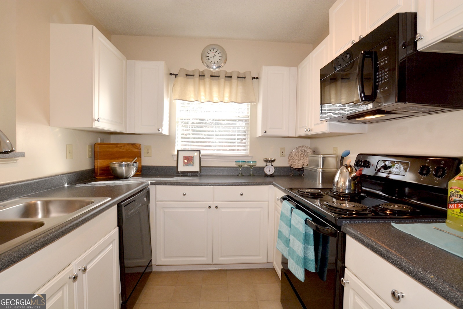 a kitchen with a sink stove top oven and cabinets