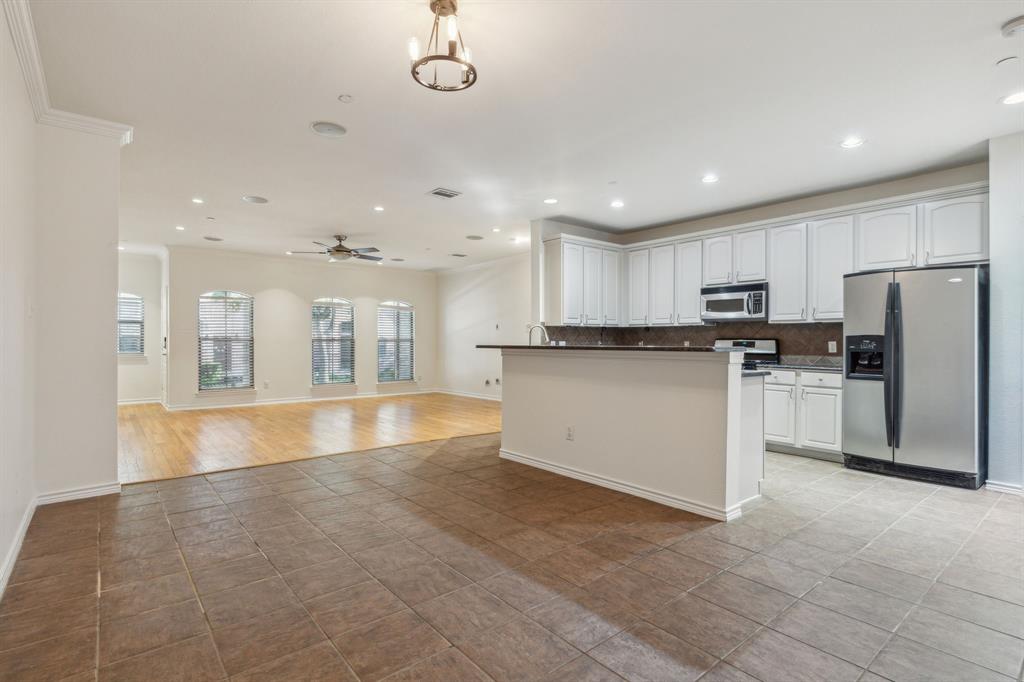 a large kitchen with cabinets in it and stainless steel appliances